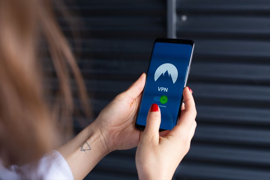 Dłonie trzymające smartfon z włączoną aplikacją VPN na ekranie