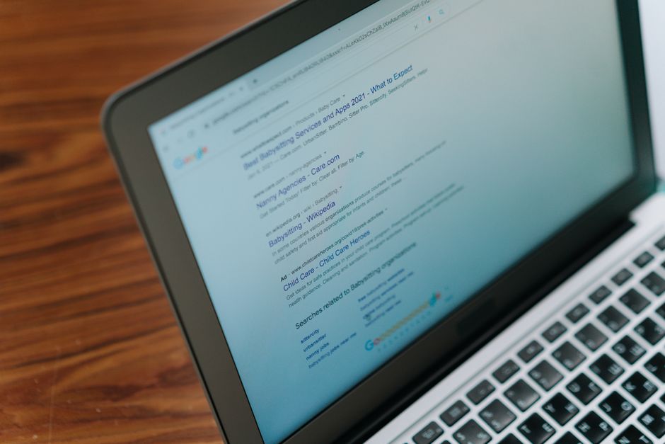 Ekran laptopa z wynikami wyszukiwania Google zawierającymi reklamę oraz organiczne linki.